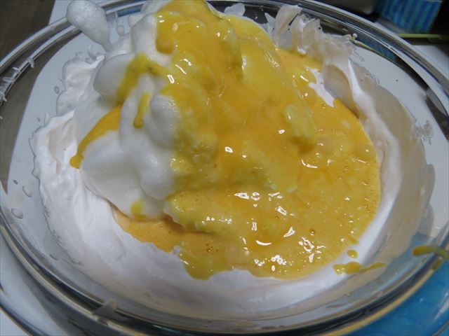 泡立てた生クリームに卵黄とメレンゲを混ぜ合わせる